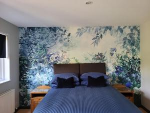 贝克韦尔The Garden Rooms at Tannery House的一间卧室配有蓝色的床和花卉壁纸