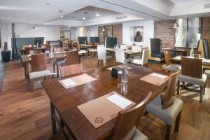 萨尔蒂约喜来登萨尔蒂福朋酒店的用餐室配有木桌和椅子