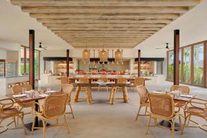 TanjungbingaSheraton Belitung Resort的开放式厨房和带桌椅的用餐室