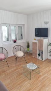 马鲁希奇Villa Silvana Brown的客厅配有2把椅子和平面电视