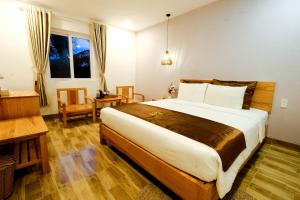 富国BB Hotel&Resort的一间卧室配有一张床、一张书桌和一个窗户。
