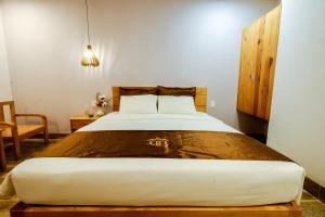 富国BB Hotel&Resort的一间卧室配有一张大床和木制床头板