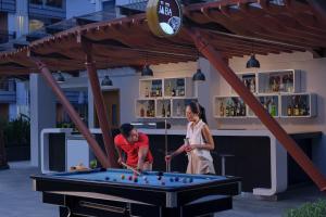 库塔Fairfield by Marriott Bali Kuta Sunset Road的男女在台球桌打台球