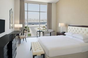 迪拜Delta Hotels by Marriott Dubai Investment Park的卧室设有白色的床和大窗户