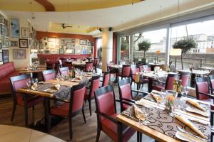 杜塞尔多夫万豪度假酒店杜塞尔多夫港店的餐厅设有木桌、椅子和大窗户。