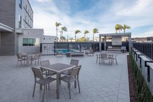 洛斯阿拉米托斯Fairfield by Marriott Inn & Suites Anaheim Los Alamitos的毗邻大楼的带桌椅的天井