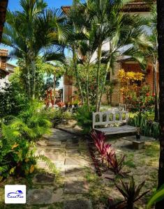 皮帕Casa Tua Pipa的一个带长凳和棕榈树的花园