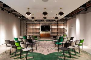 伦敦Bankside Hotel, Autograph Collection的一间会议室,配有绿色椅子和屏幕