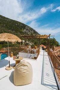 科帕罗Villa Porta Qeparo的从带桌子和遮阳伞的度假村屋顶欣赏美景
