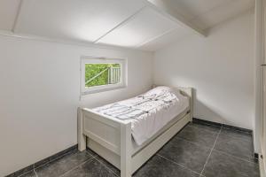 东代恩凯尔克De Zeevijver Oostduinkerke的一间白色的小卧室,配有床和窗户