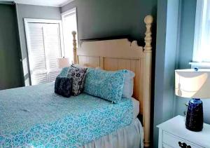 博福特Cozy Marine Corps Home Near MCRD w/ a Beach Pass的一间卧室配有一张带蓝色床单的床和一扇窗户。