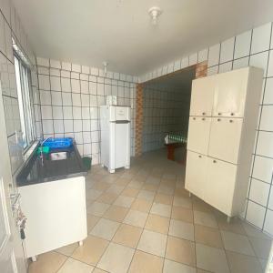 弗洛里亚诺波利斯Barra da Lagoa Guest House的带冰箱的厨房和瓷砖地板。