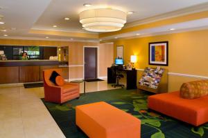 芬顿圣路易·芬顿费尔菲尔德客栈的酒店大堂设有橙色椅子和书桌