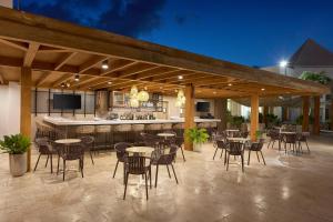 棕榈滩Courtyard by Marriott Aruba Resort的一个带桌椅的庭院和一间酒吧