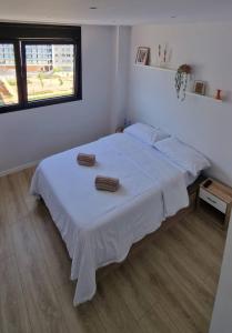 巴塞罗那Habitación confortable para parejas (1)的卧室配有白色的床和2条毛巾