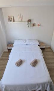 巴塞罗那Habitación confortable para parejas (1)的卧室配有一张带两个枕头的大白色床