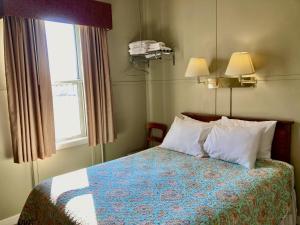 GardenGarden Grove Retreat & Lodging near Pictured Rocks, Fayette, Trails的卧室配有带枕头的床铺和窗户。