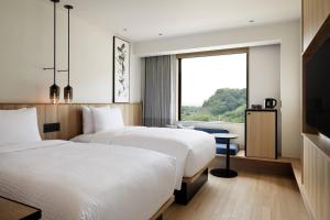 美浓加茂市Fairfield by Marriott Gifu Seiryu Satoyama Park的配有窗户的酒店客房内的两张床