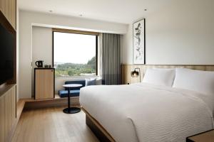 美浓加茂市Fairfield by Marriott Gifu Seiryu Satoyama Park的酒店客房设有床和窗户。