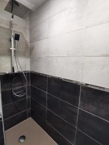 Longues-sur-MerLa chaumière的浴室铺有黑白瓷砖,设有淋浴。