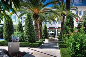 瓦伦西亚瓦伦西亚威斯丁酒店的一座种有棕榈树的花园及一座建筑