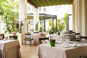 瓦伦西亚瓦伦西亚威斯丁酒店的餐厅配有桌椅和白色桌布