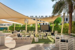 艾恩艾恩雅乐轩酒店的一个带白色椅子和屏风的庭院,并种植了棕榈树