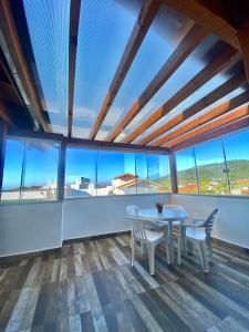 弗洛里亚诺波利斯Barra da Lagoa Guest House的一间带桌椅和大窗户的用餐室
