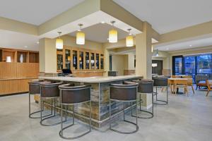 印第安纳波利斯TownePlace Suites by Marriott Indianapolis Downtown的大堂设有带凳子和桌子的酒吧