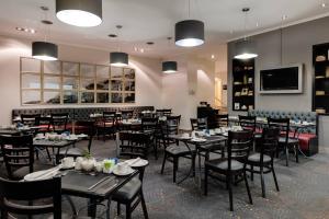 贝尔维尔开普敦泰格谷万豪Protea酒店的用餐室配有桌椅