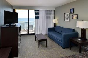 弗吉尼亚海滩弗吉尼亚海滩海滨福朋喜来登酒店的客厅配有蓝色的沙发和电视