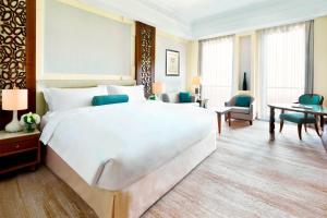 马斯喀特Al Bustan Palace, a Ritz-Carlton Hotel的一间大卧室,配有一张白色的大床和一张书桌