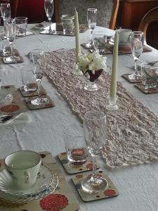 温耶德亚历山大住宿加早餐旅馆的白桌布上带眼镜和蜡烛的桌子