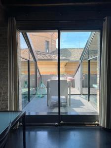 帕尔马Ardesia Exclusive Apartament的客房设有带桌子的大窗户,位于庭院