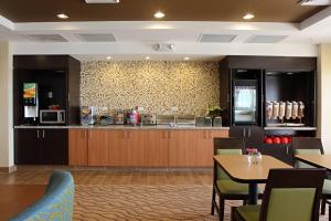 沃尔顿堡滩华尔顿堡滩-恩格林空军基地唐尼普莱斯套房酒店的餐厅设有带柜台和桌子的厨房