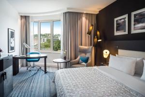 斯图加特梅里迪安斯图加特酒店的配有一张床和一张书桌的酒店客房