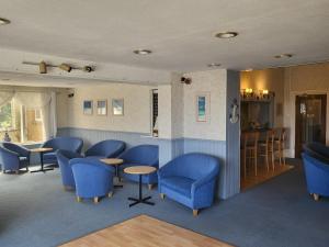 尚克林东山大厅酒店的一间设有蓝色椅子的等候室和一间酒吧