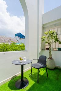 胡志明市La Serena Hotel & Apartment的阳台配有桌椅和窗户