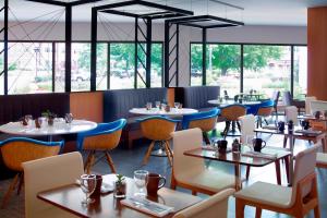 代顿代顿大学万豪酒店的餐厅设有桌椅和窗户。