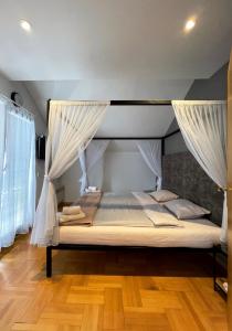 佩奇Town hostel的一间卧室配有带窗帘的天蓬床