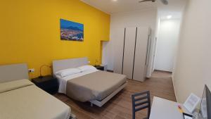 那不勒斯Terminal 1 Guest House的一间卧室设有两张床和黄色的墙壁