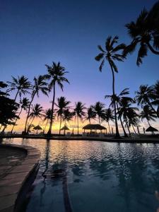 雅帕拉廷加比特恩吉尔帕亚酒店的棕榈树和日落的游泳池