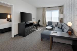印第安纳波利斯Residence Inn by Marriott Indianapolis Keystone的酒店客房设有沙发、床和电视。