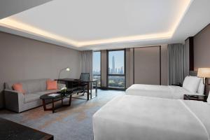 深圳金茂深圳 JW 万豪酒店的酒店客房配有一张床、一张沙发和一张书桌。