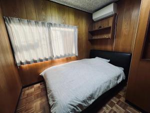 熊本SUMITSUGU HOUSE Grandpa的一间小卧室,配有床和窗户
