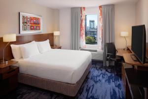纽约纽约曼哈顿/市中心东费尔菲尔德套房酒店的配有一张床、一张书桌和一扇窗户的酒店客房