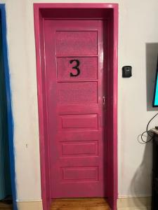 里斯本Rostelbem Guesthouse Lisbon的粉红色的门,上面有三号