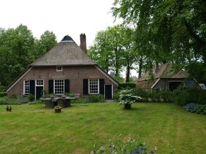 HeerdeLandgoedhoeve Vosbergen的一座带茅草屋顶的老砖屋
