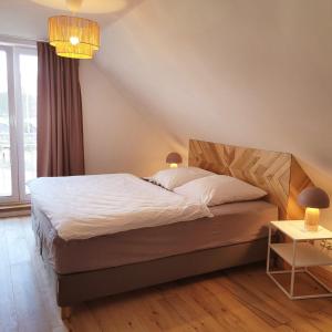 赖因斯贝格Haus am Seeufer的一间卧室配有一张带白色床单的床和一扇窗户。