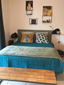 安格雷COSY ROOM PRIVATE BATH AND GARDEN的一间卧室配有一张带蓝色床单和枕头的床。